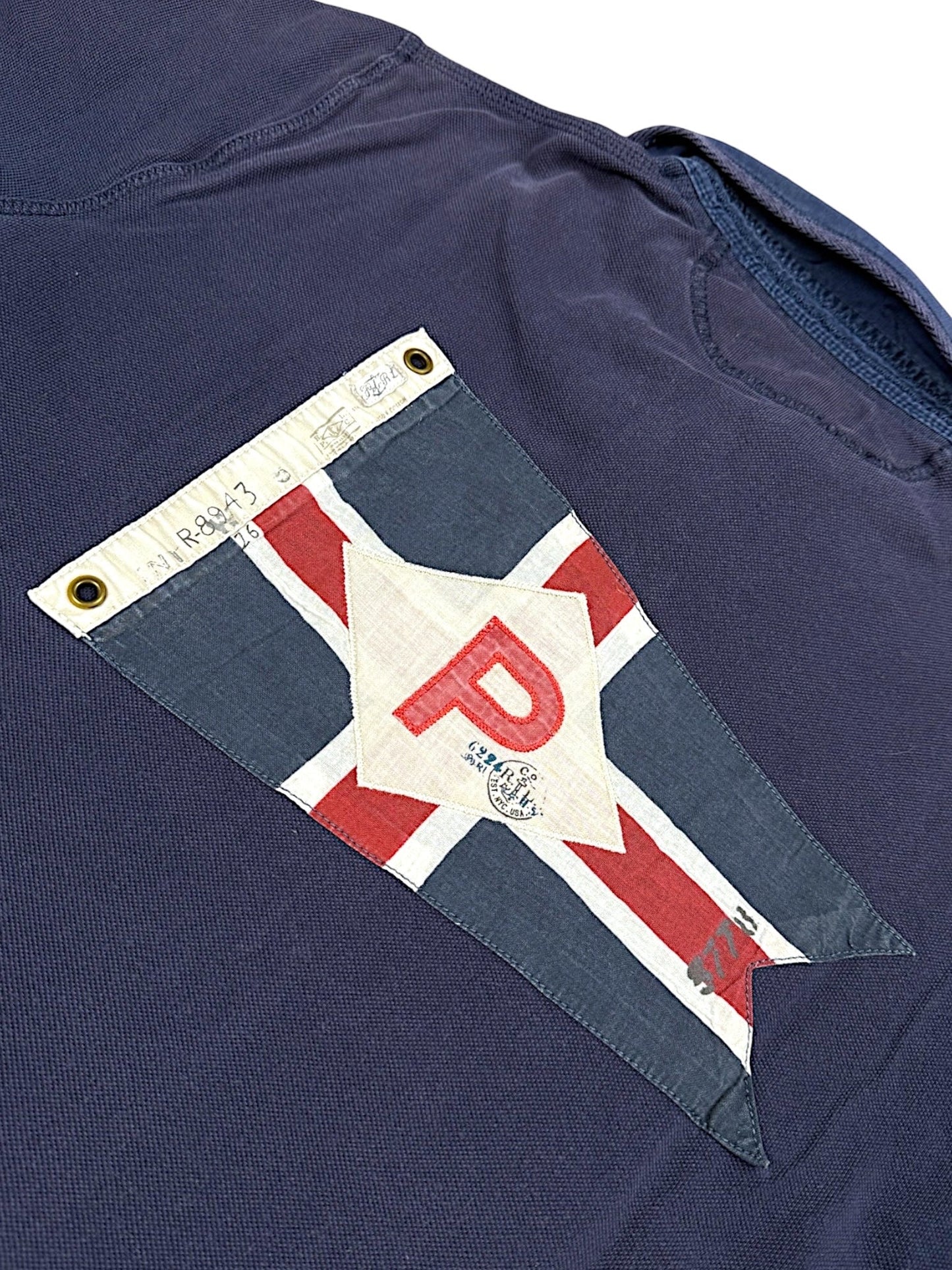 XTENDED Vintage Ralph Lauren navy blue cotton polo shirt with a pennant flag patch on the chest featuring a red 'P'.