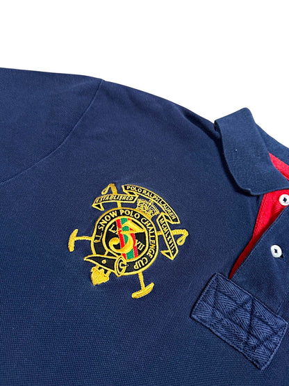 XTENDED Vintage navy blue cotton polo shirt with red collar detail and embroidered crest featuring "Polo Ralph Lauren Snow Polo Challenge" text.