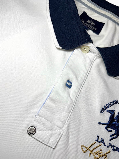 XTENDED white cotton polo shirt with navy collar and blue embroidered horse logo. Features a button placket and vintage detailing.