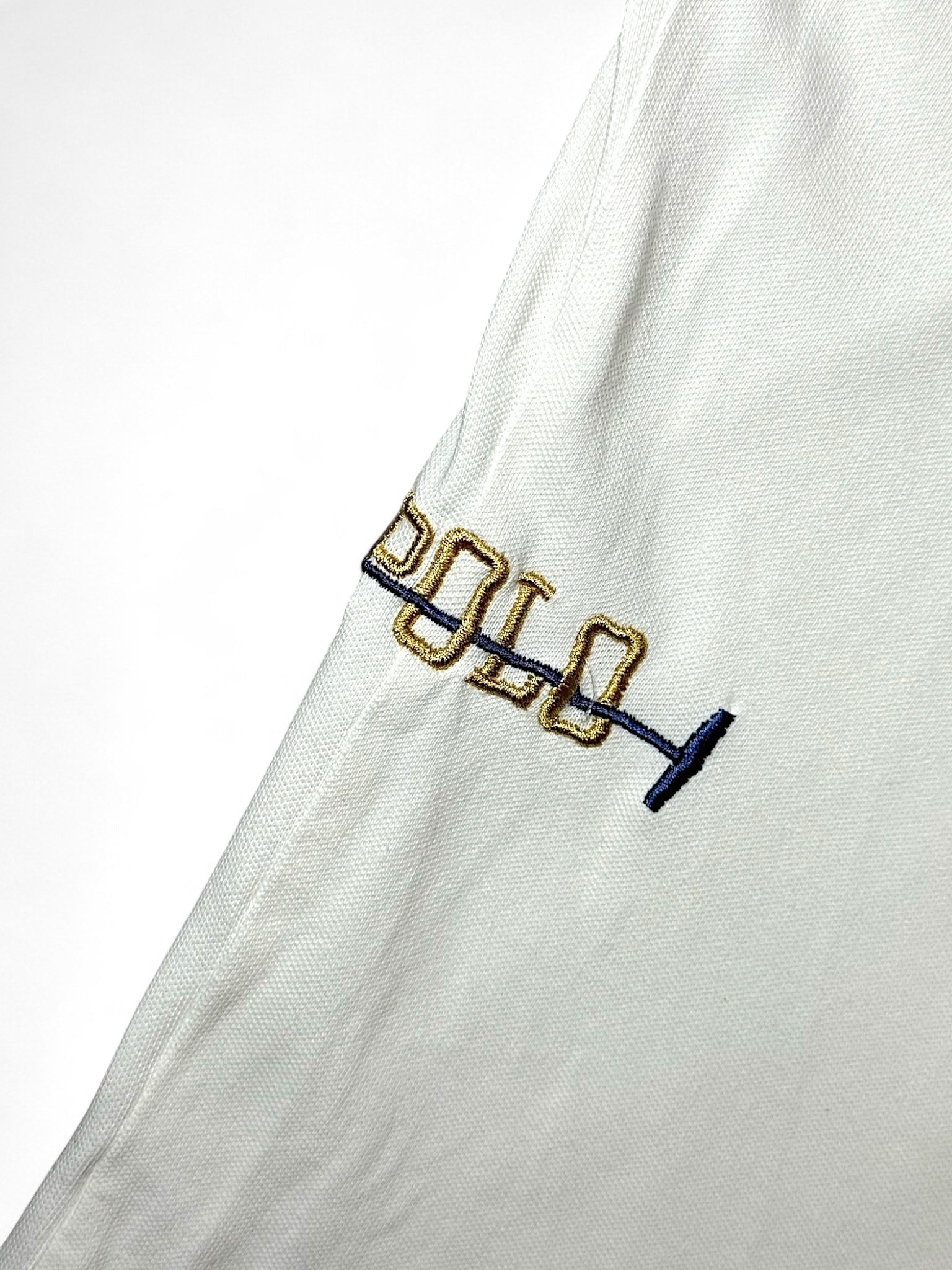 XTENDED white cotton polo shirt with embroidered gold and blue 'polo' text and mallet detail.