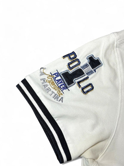 XTENDED vintage white cotton polo shirt with navy and gold embroidered 'Player Polo La Martina' logo on sleeve and striped cuffs.